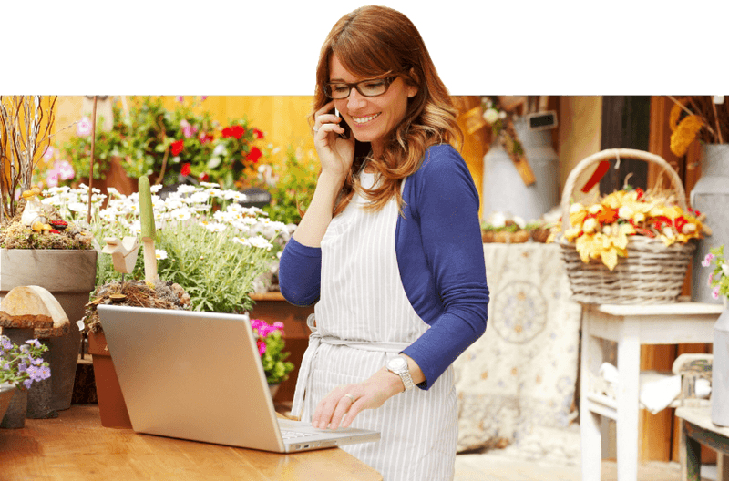 Small business woman speaking and phone while using SureCommand Standard modules on laptop